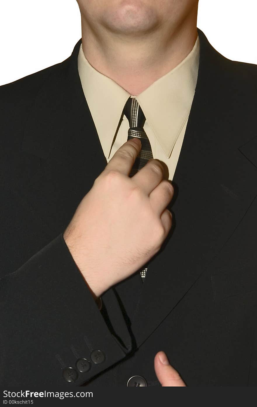 Young man in a black strict suit corrects for a tie on a white background. Young man in a black strict suit corrects for a tie on a white background