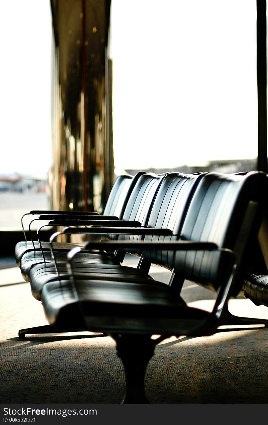 A row of empty airport lounge seating. A row of empty airport lounge seating