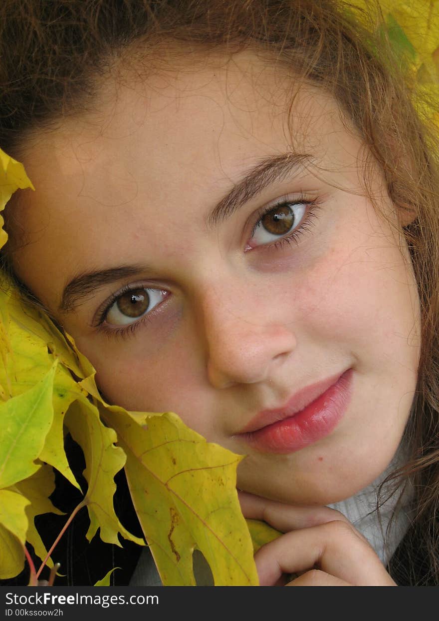 The portrait of  young girl with yellow leaves in an autumn. The portrait of  young girl with yellow leaves in an autumn