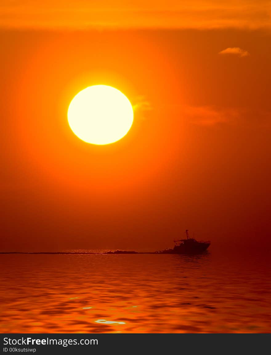 Orange sunset and boat in the sea
