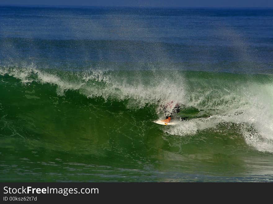 An image of a surfer doing a maneuver in the barrel. An image of a surfer doing a maneuver in the barrel.