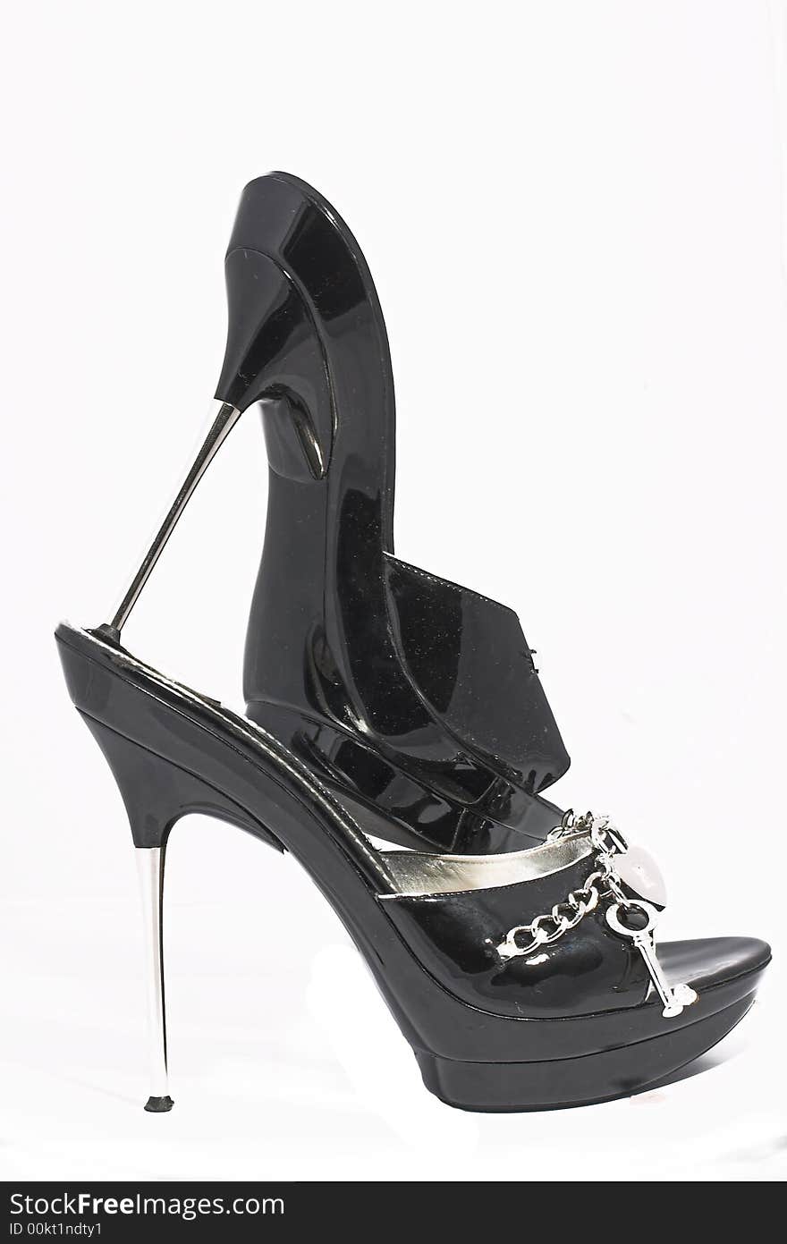 Black shoes from a varnish leather with chains and ornaments of silver on a sharp thin steel heel