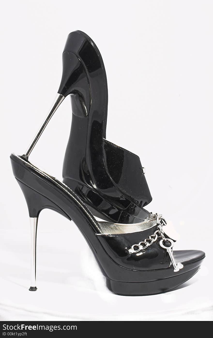 Black shoes from a varnish leather with chains and ornaments of silver on a sharp thin steel heel