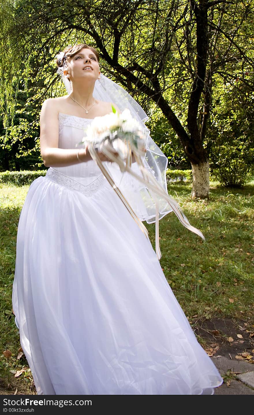 Bride with bouquet of flowers against a background of forest