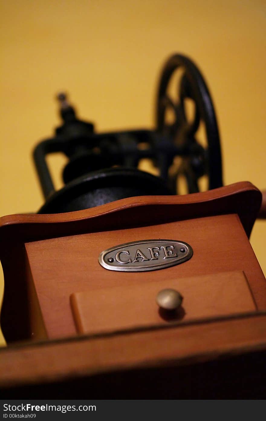 An antique coffee grinder with a metal CAFE label.