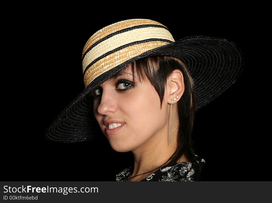 The young smiling girl in a straw hat, on a black background. The young smiling girl in a straw hat, on a black background