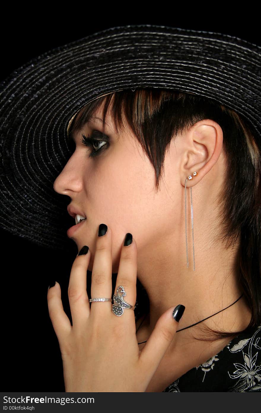 The young beautiful girl in a straw hat, on a black background. The young beautiful girl in a straw hat, on a black background