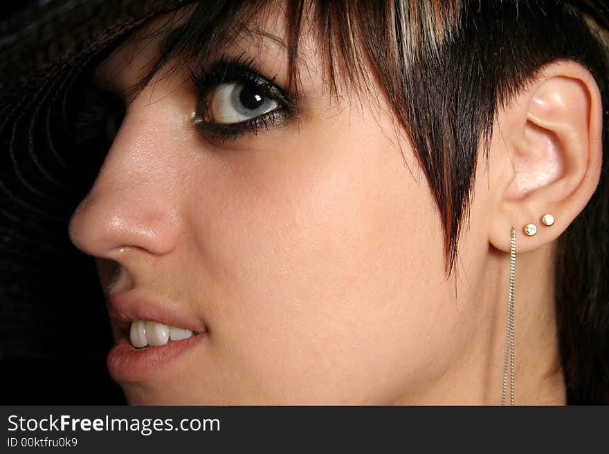 The young beautiful girl in a hat, on a black background. The young beautiful girl in a hat, on a black background