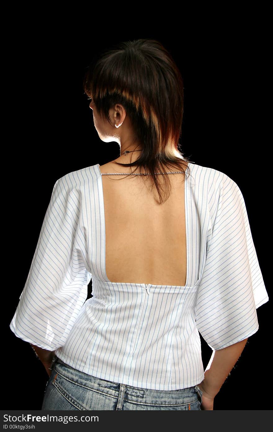 The young woman with the open back, isolated on black