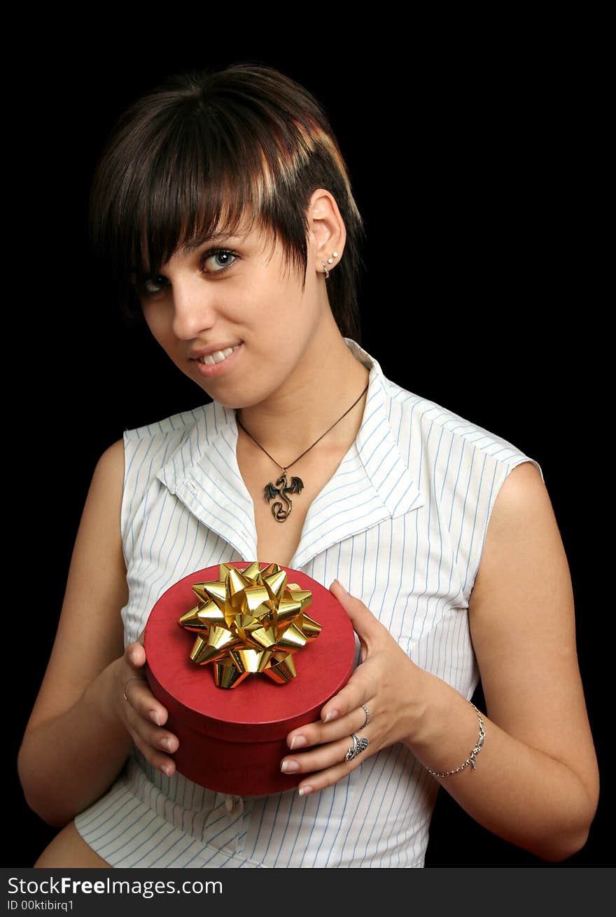 The young girl holds a box with a gift, isolated on black background