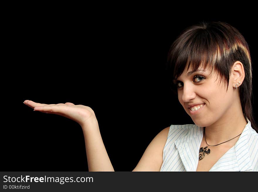 The young girl holds something in a hand, is isolated on a black background