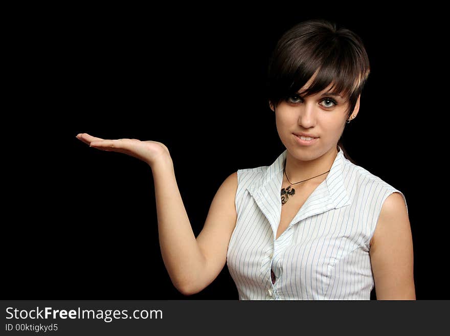 The young girl holds something in a hand, is isolated on a black background