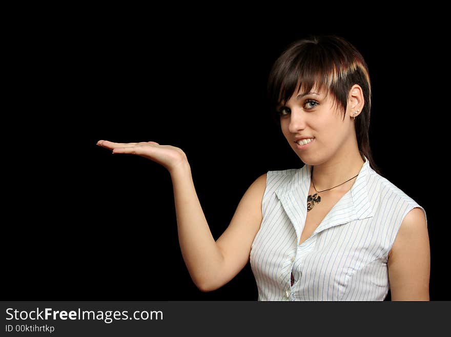 The young girl holds something in a hand, is isolated on a black background