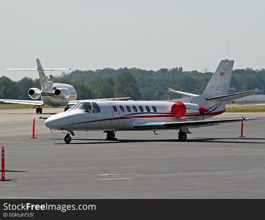 A red and white jet parked on the tarmac