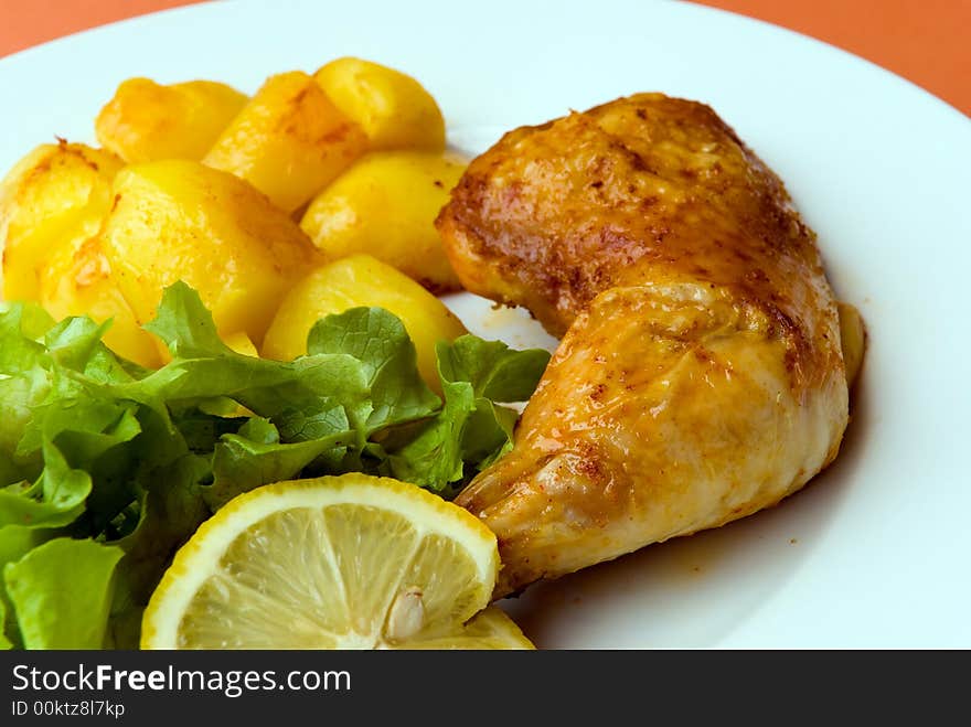 Roasted chicken legs with potatoes and salad.