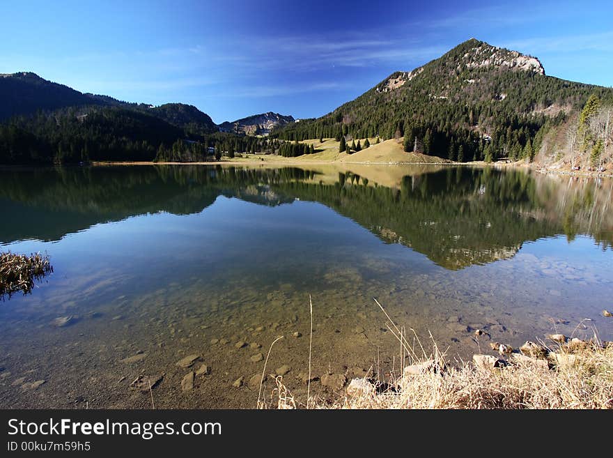 Clear lake in mountains with a mirror-flat surface. Clear lake in mountains with a mirror-flat surface