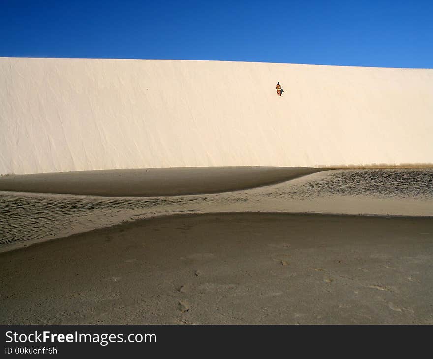 Girl going up a dune in the National Park of the Lencois Maranhenses - North of Brazil. Girl going up a dune in the National Park of the Lencois Maranhenses - North of Brazil