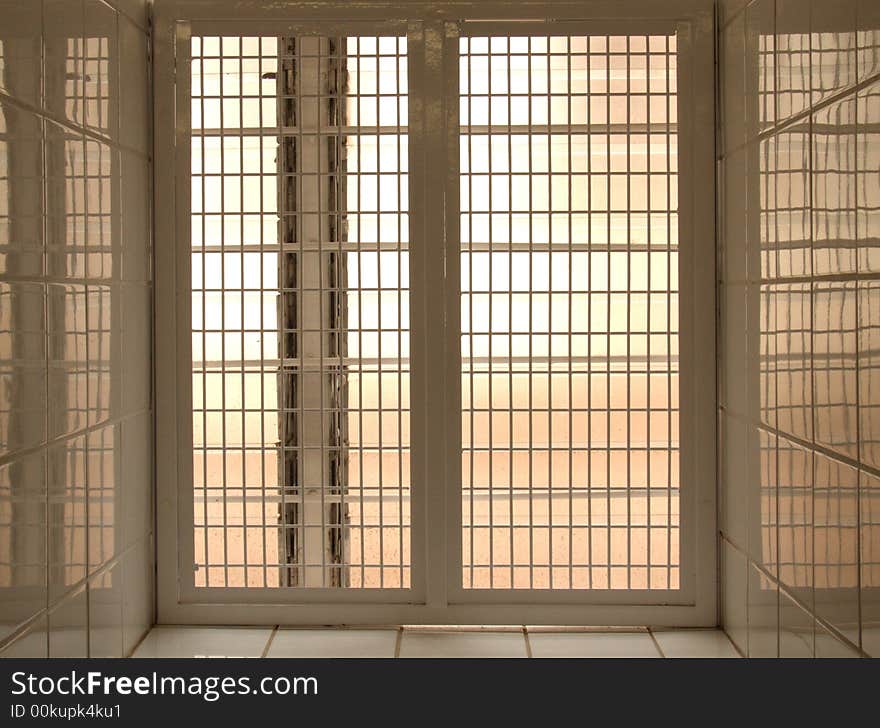 A barricaded window in a white tiled surround