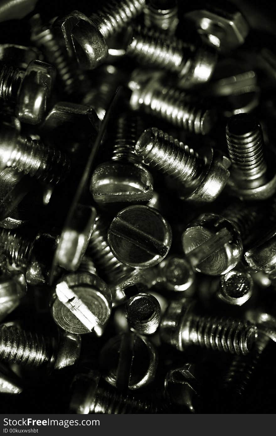 A detail of a pile of male- and female-screw bolts, toned in one color.