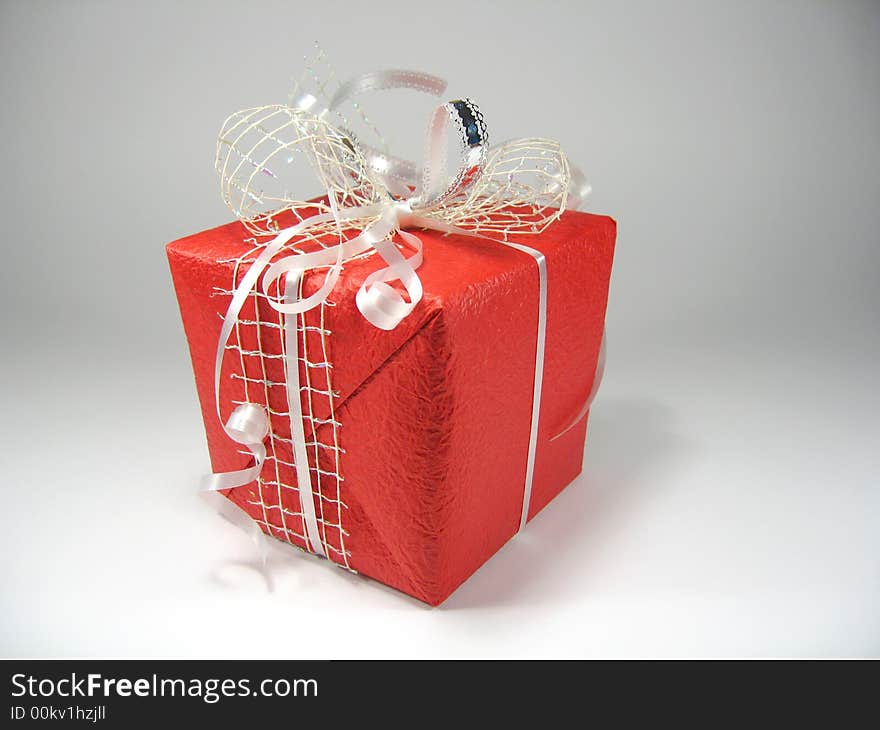 Gift in a red box with a bow on a white background