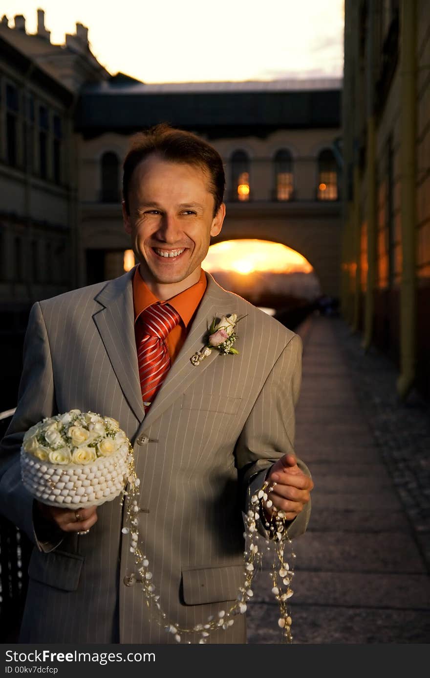 Groom with a bouquet of white roses