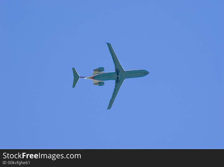 A jet flying overhead with a blue sky in the background. A jet flying overhead with a blue sky in the background