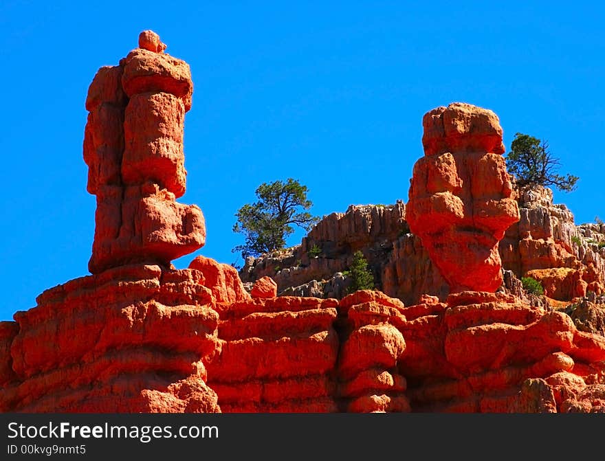 Two wind sculpted red sandstone hoodoos projected against a deep blue sky. Two wind sculpted red sandstone hoodoos projected against a deep blue sky.