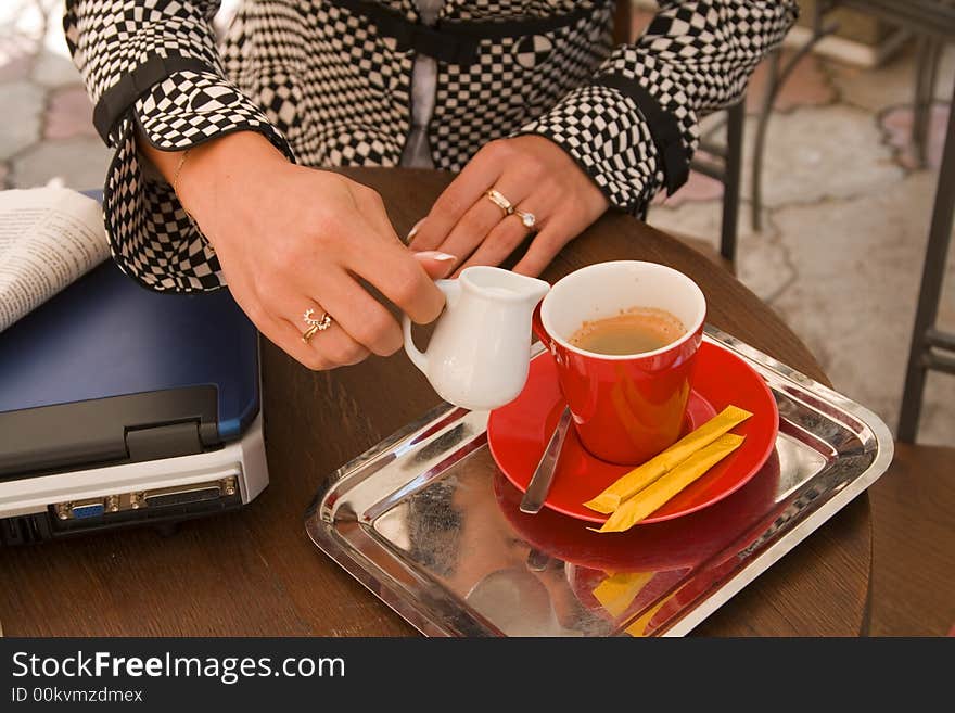 Businesswoman hands preparing coffee latte on a terrace.