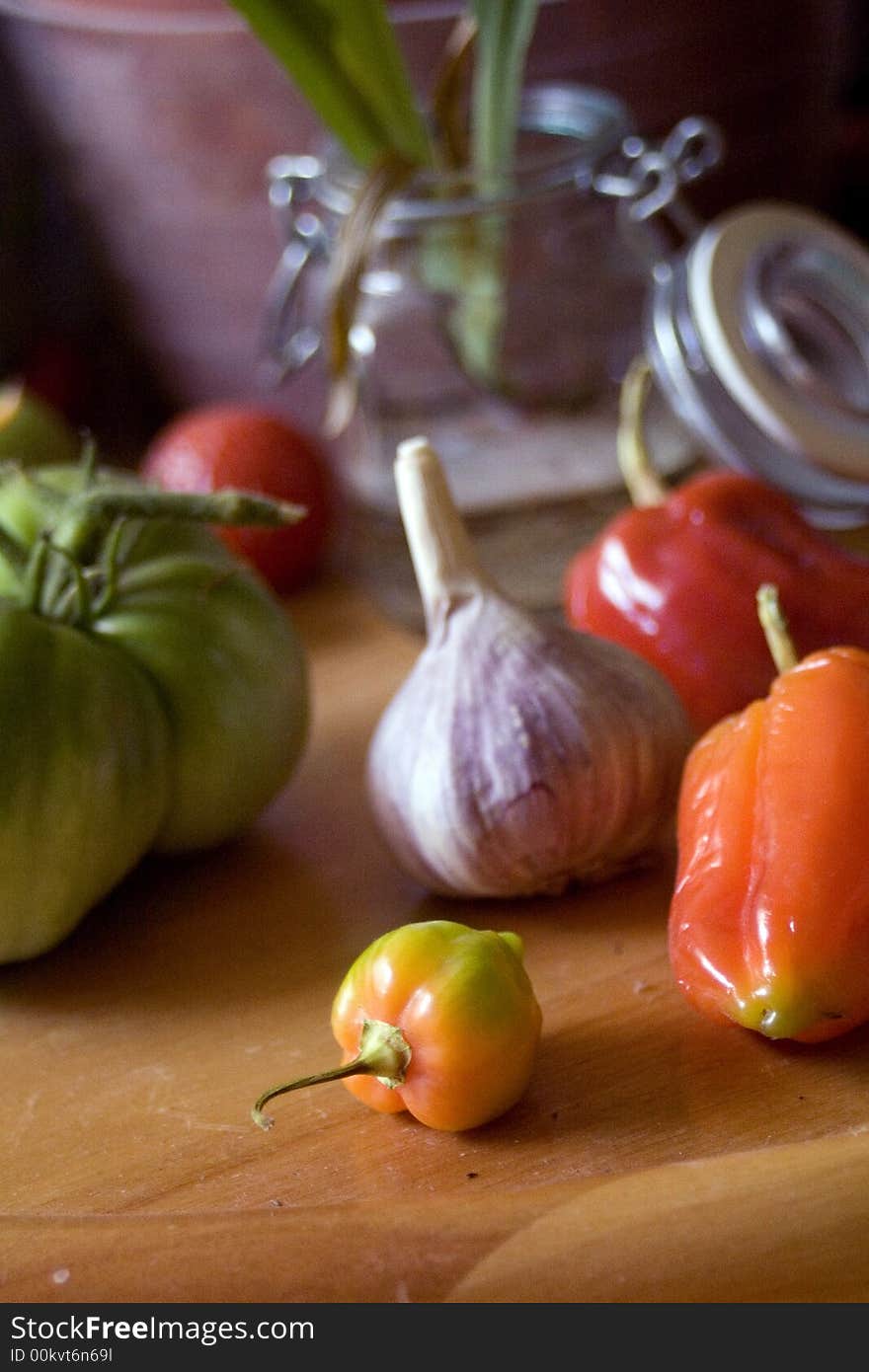 Purple Garlic Bulb, peppers and tomato with a jar in the background. Purple Garlic Bulb, peppers and tomato with a jar in the background.