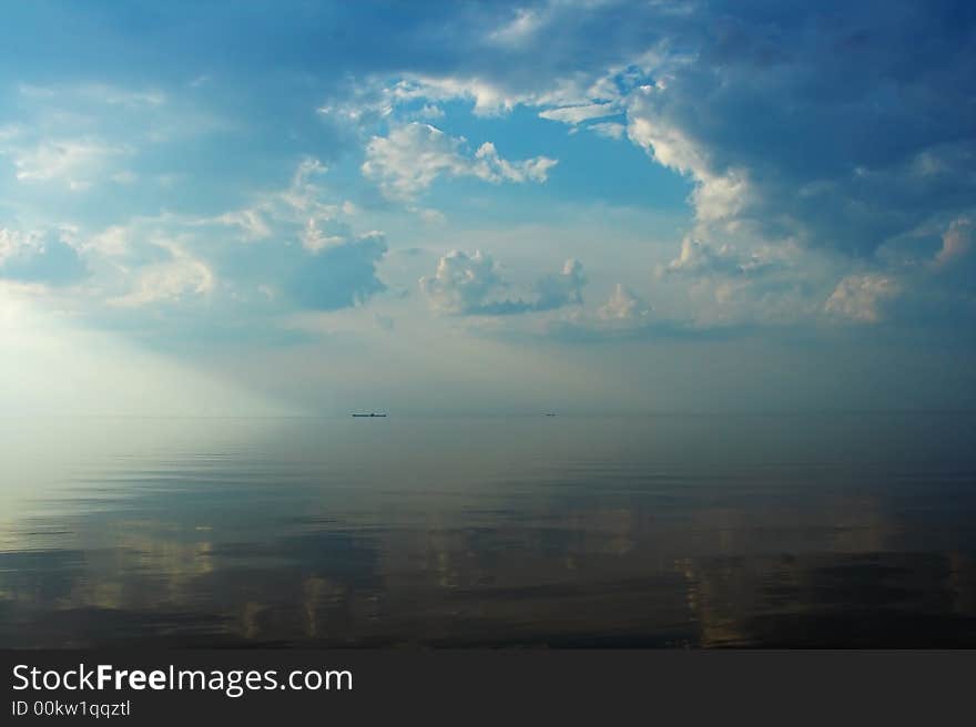 Sun and clouds are reflecting in still water. Sun and clouds are reflecting in still water