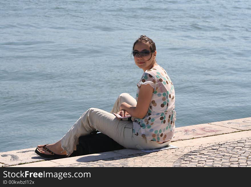 A pretty girl sitting at the sea. A pretty girl sitting at the sea