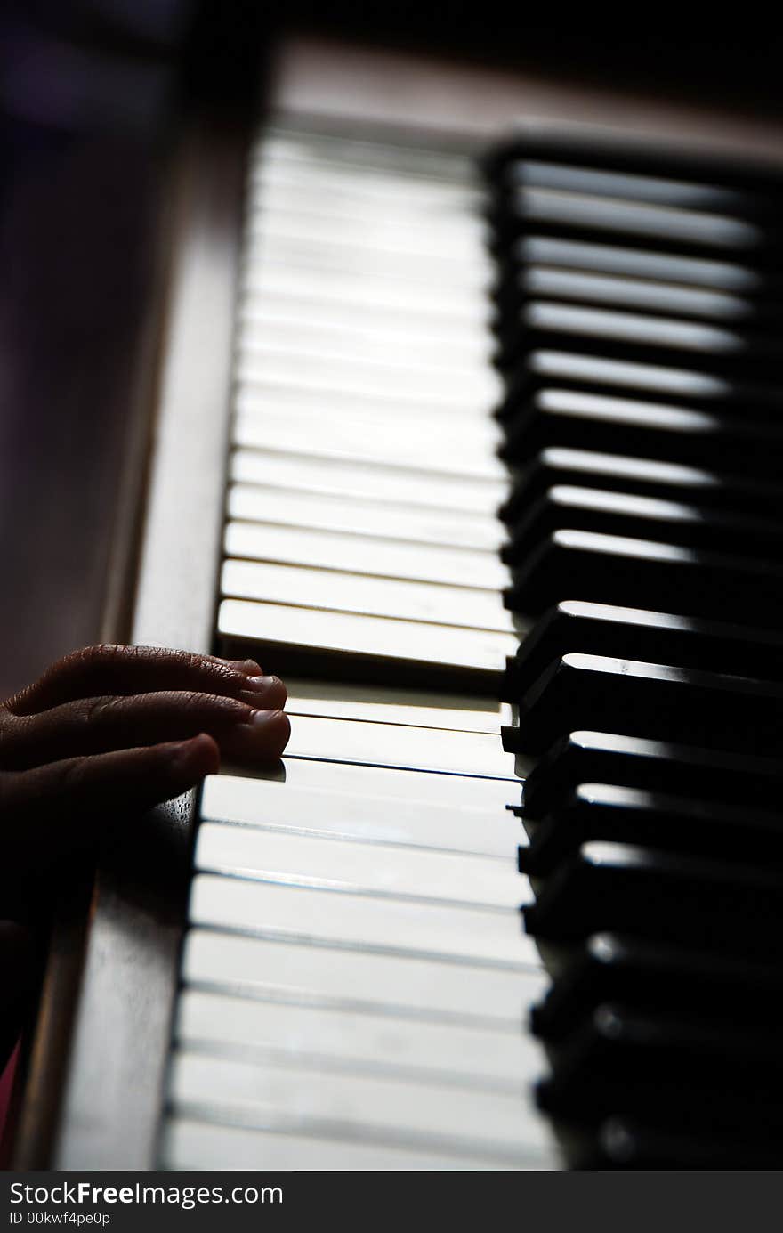 A toddler places his hand on piano keys. A toddler places his hand on piano keys