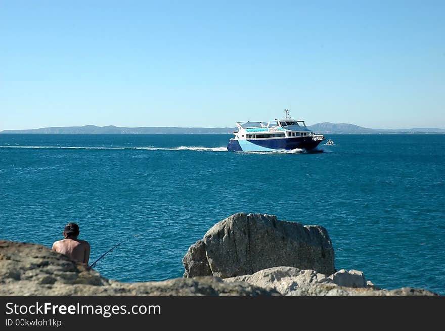 Man is fishing in relax whit a luxury boat on background. Man is fishing in relax whit a luxury boat on background