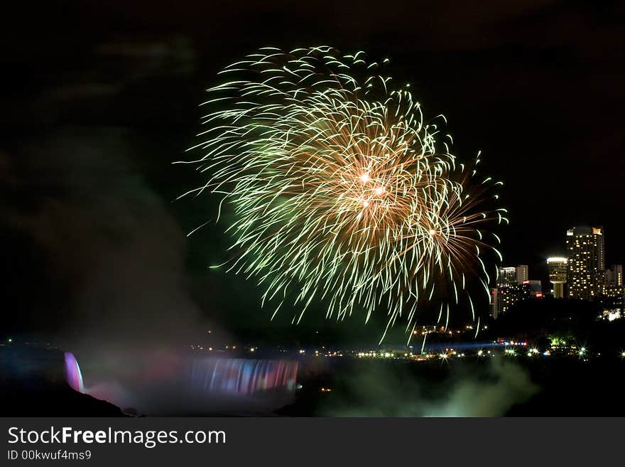 Firework went off on the niagara fall waterfall which lit by effect lights. Firework went off on the niagara fall waterfall which lit by effect lights