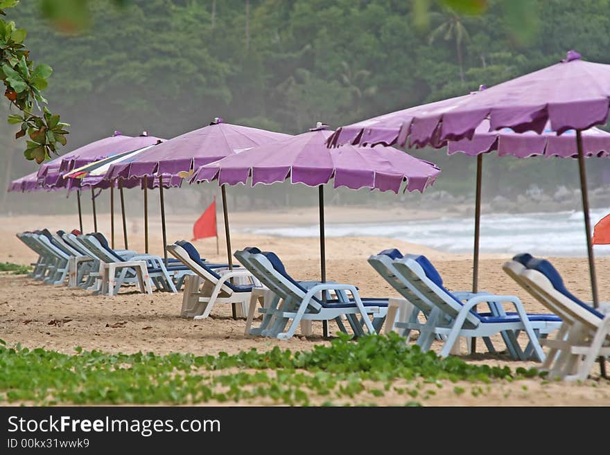 Deserted sunloungers on a tropical beach in Thailand. Deserted sunloungers on a tropical beach in Thailand