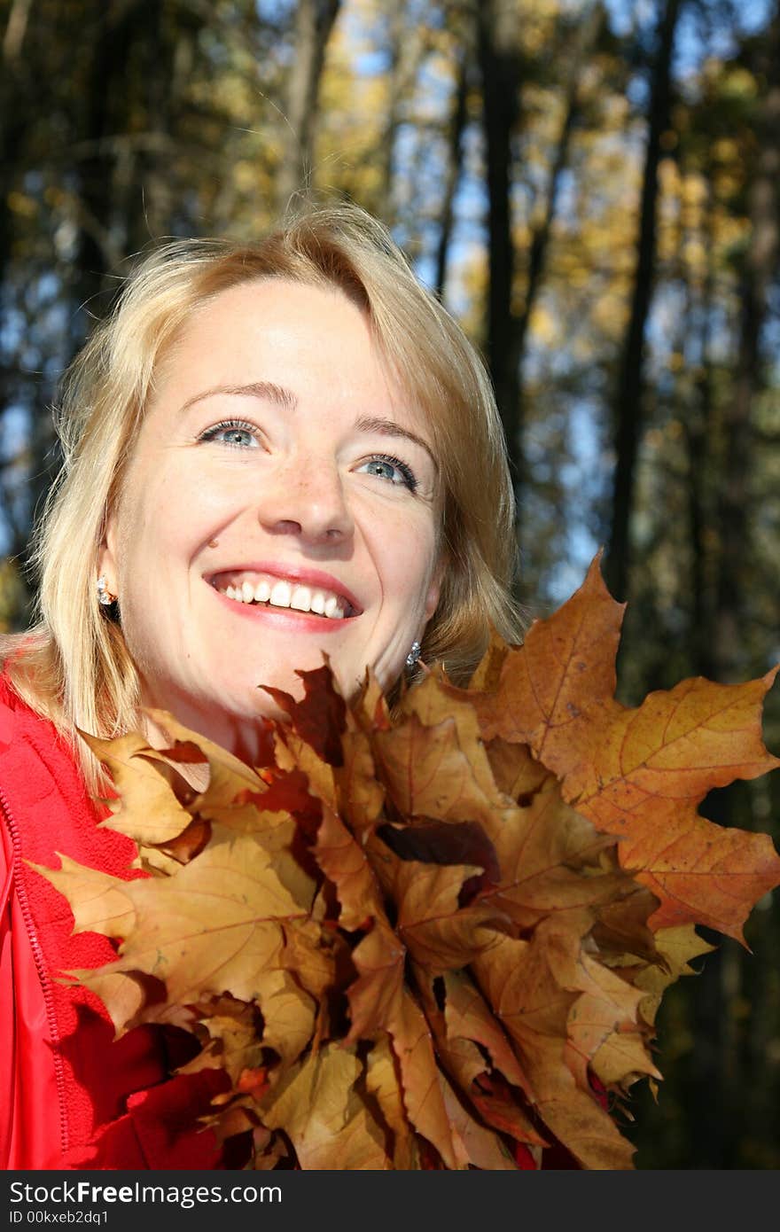 The beautiful girl with leaves of a maple