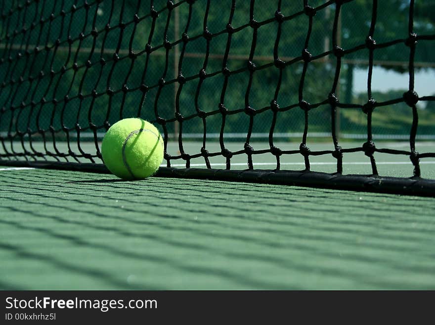 A Tennis ball near net with showdows