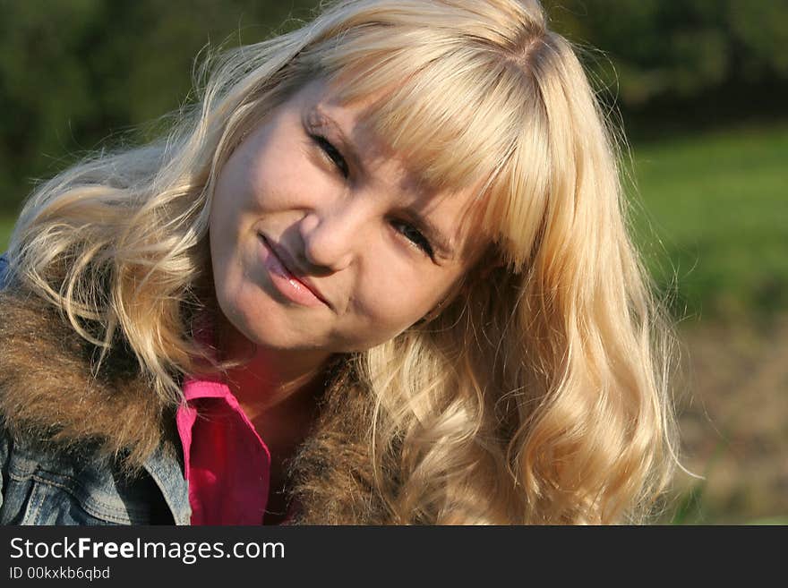 Young blond woman is sitting on a grass. Young blond woman is sitting on a grass