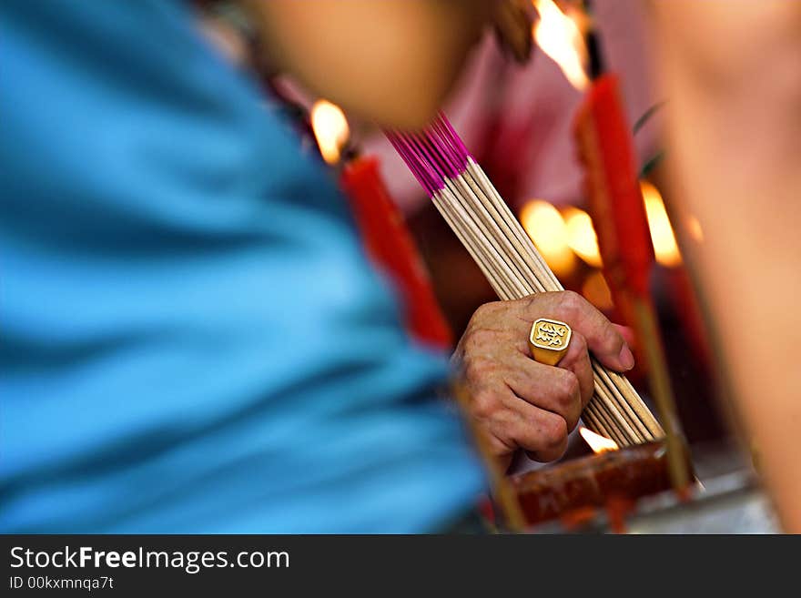 Seeking prosperity through prayers. The Chinese character depicted on the golden ring means prosper and reinforces the religious intent of the worshiper.