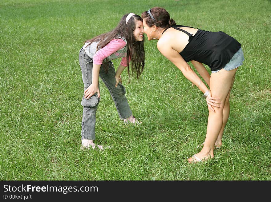 Mother and daughter stand on the grass