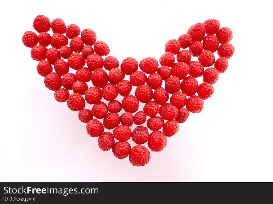 Berries of  red raspberry  hearts laid out as  symbol, love and Valentine. Berries of  red raspberry  hearts laid out as  symbol, love and Valentine