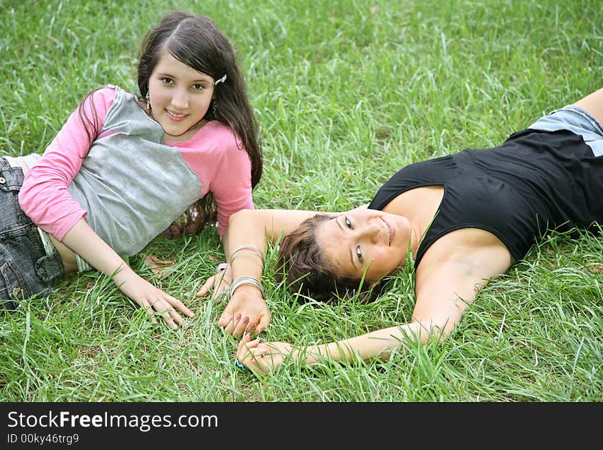 Mother and daughter-teenager lie on the grass 2