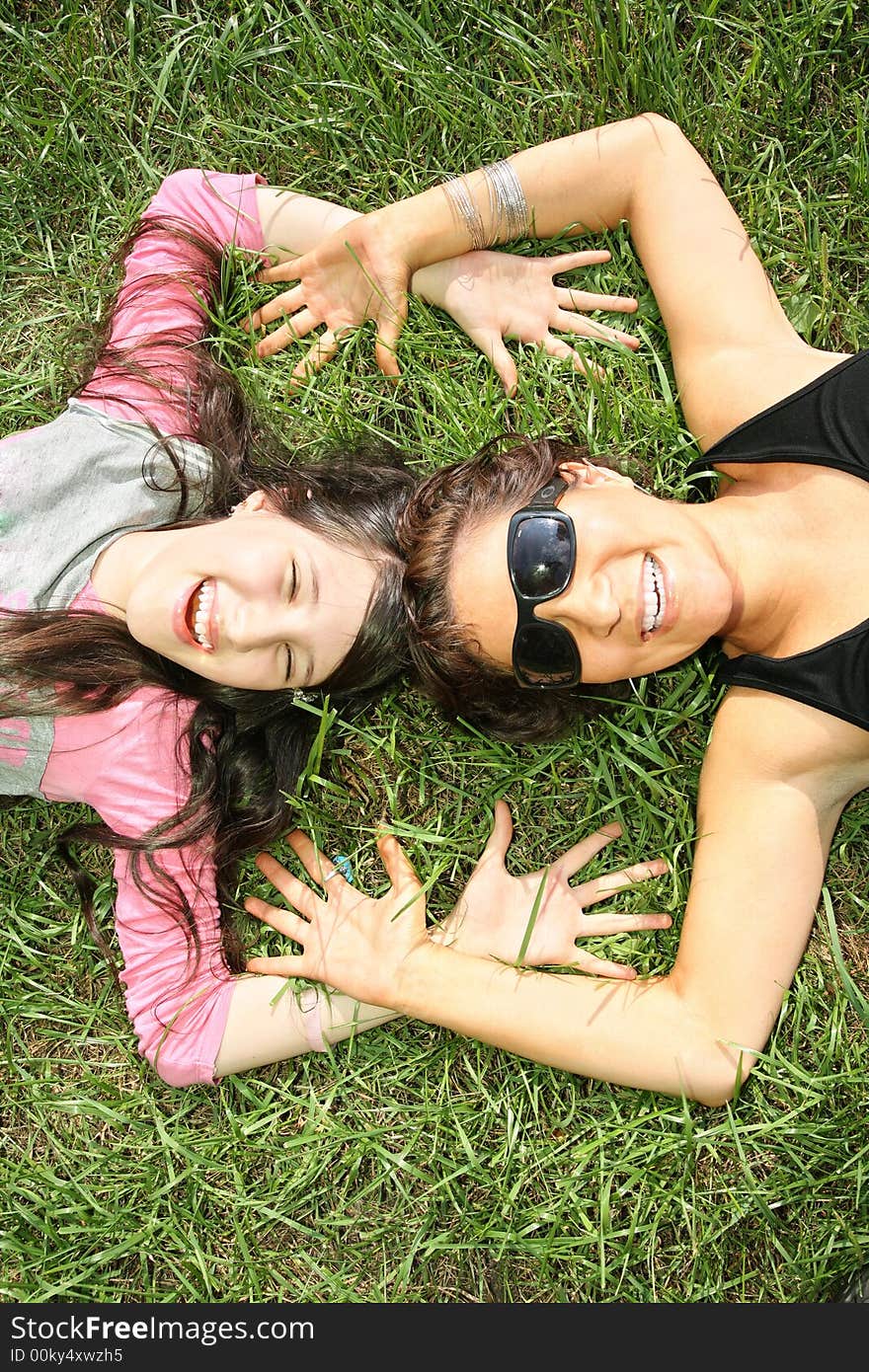 Mother and daughter lie on the grass