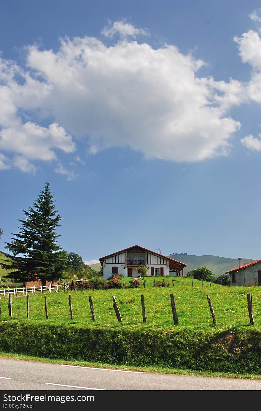 Mountain chalet with green field, pine tree and one cloud overhead. Mountain chalet with green field, pine tree and one cloud overhead