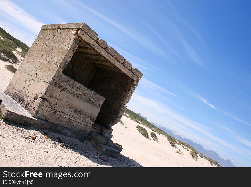 Ruins with litter on the beach at an angle against a blue sky. Ruins with litter on the beach at an angle against a blue sky