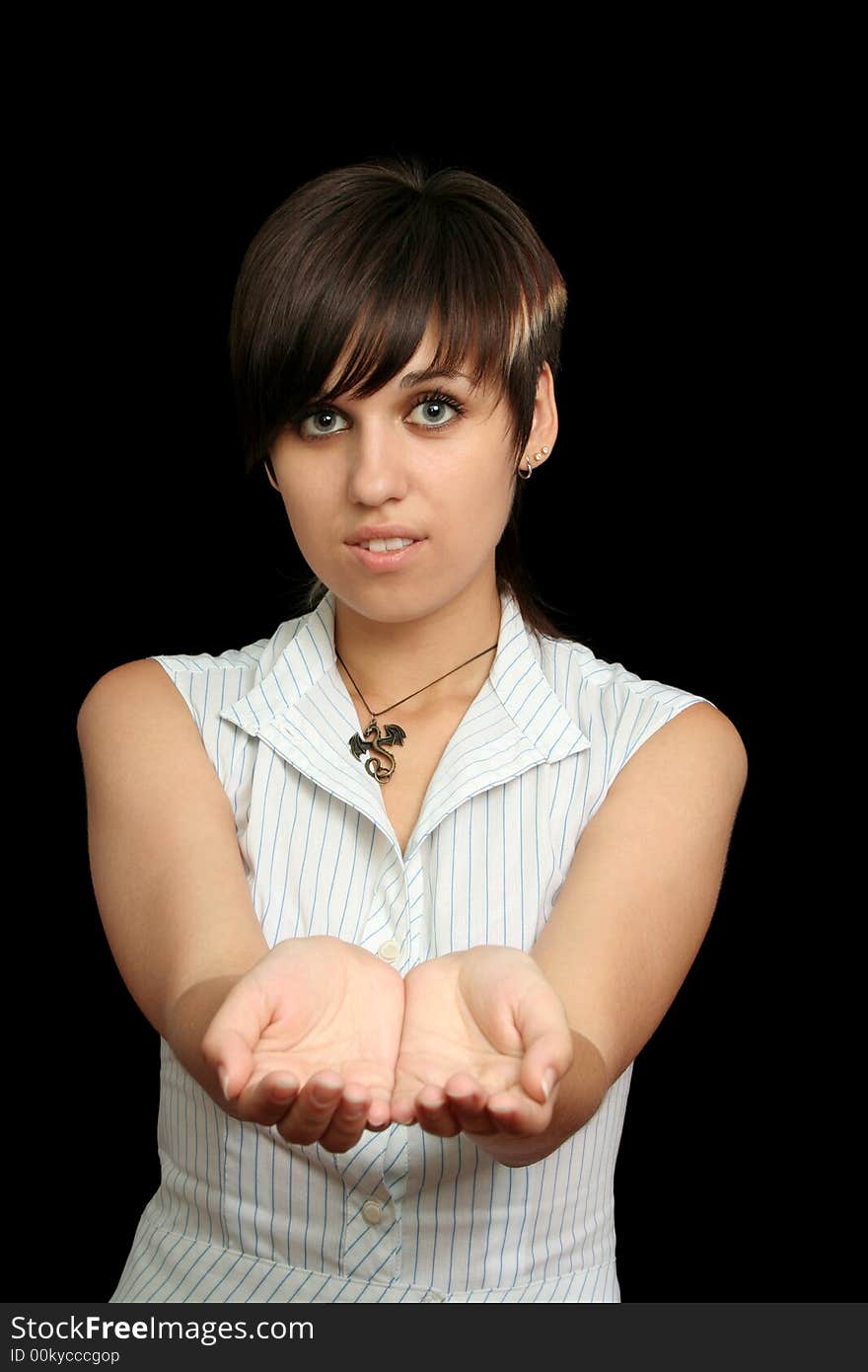 The young girl holds something in a hands, isolated on a black background