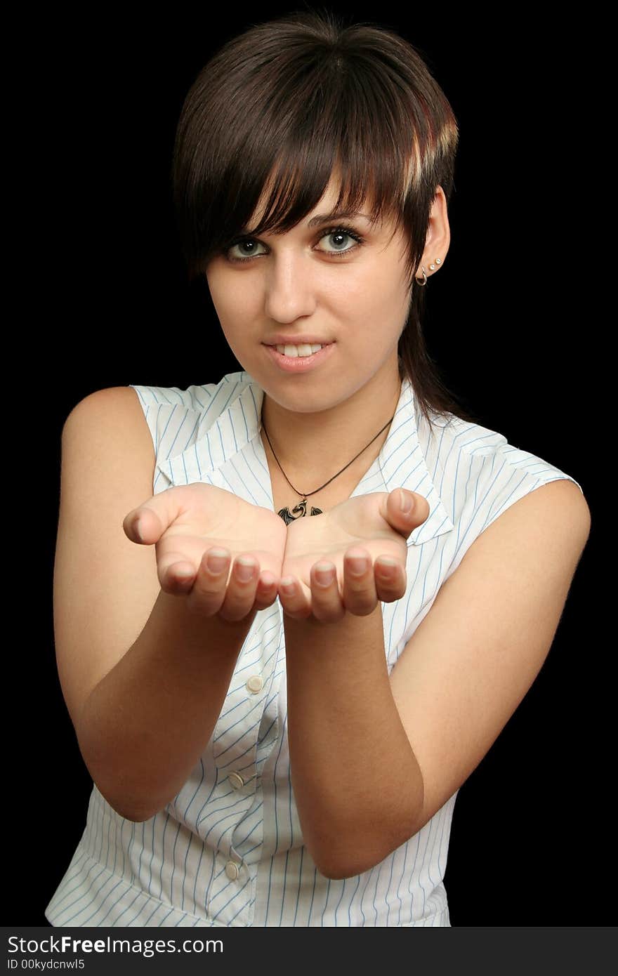 The young girl holds something in a hands, is isolated on a black background