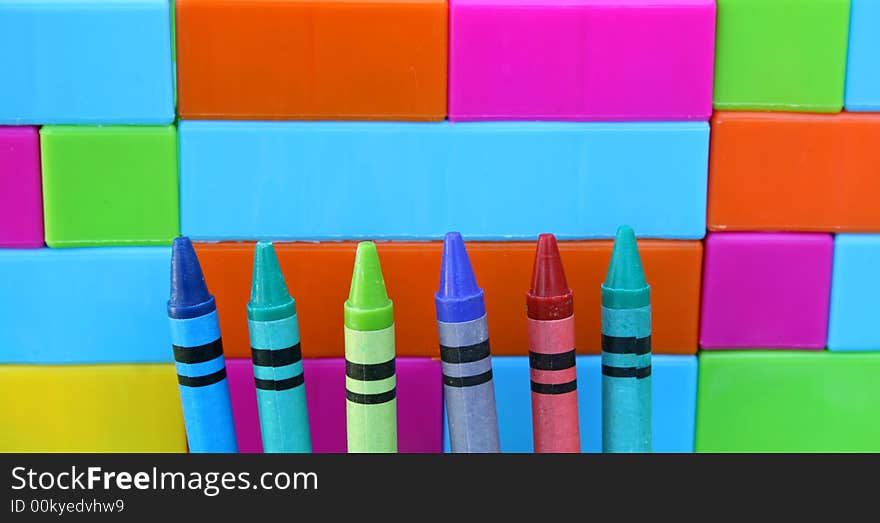 Six crayon tips against a building blocks wall