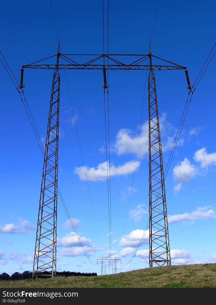 A powerline on a green field. A powerline on a green field