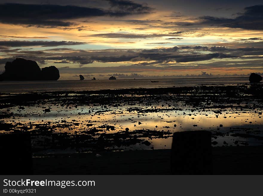 The sun sets in Hat Rai Lay as the tide goes out revealing a stony beach on the Andaman Coast. The sun sets in Hat Rai Lay as the tide goes out revealing a stony beach on the Andaman Coast.